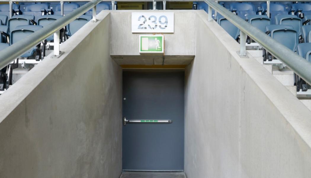 Bilden visar en ståldörr, tillverkad av Daloc, och finns på Friends Arena i Solna. Dörren har utrymningsbeslag för att möjliggöra en snabb evakuering i en nödsituation.